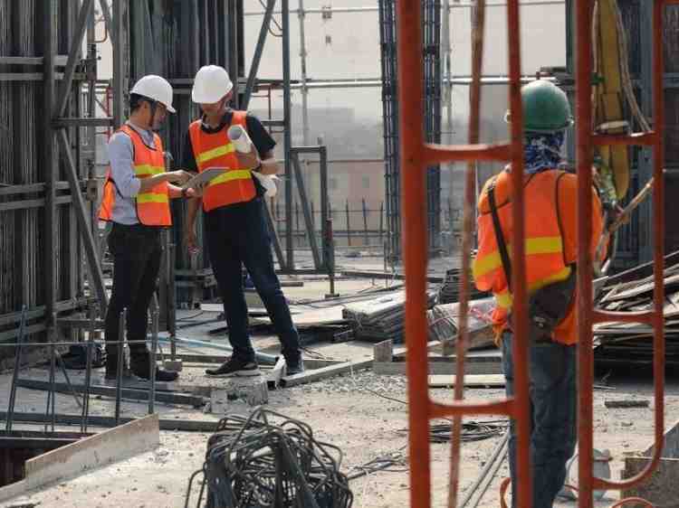 Construction crew reviewing layout marks and plans on an active building site